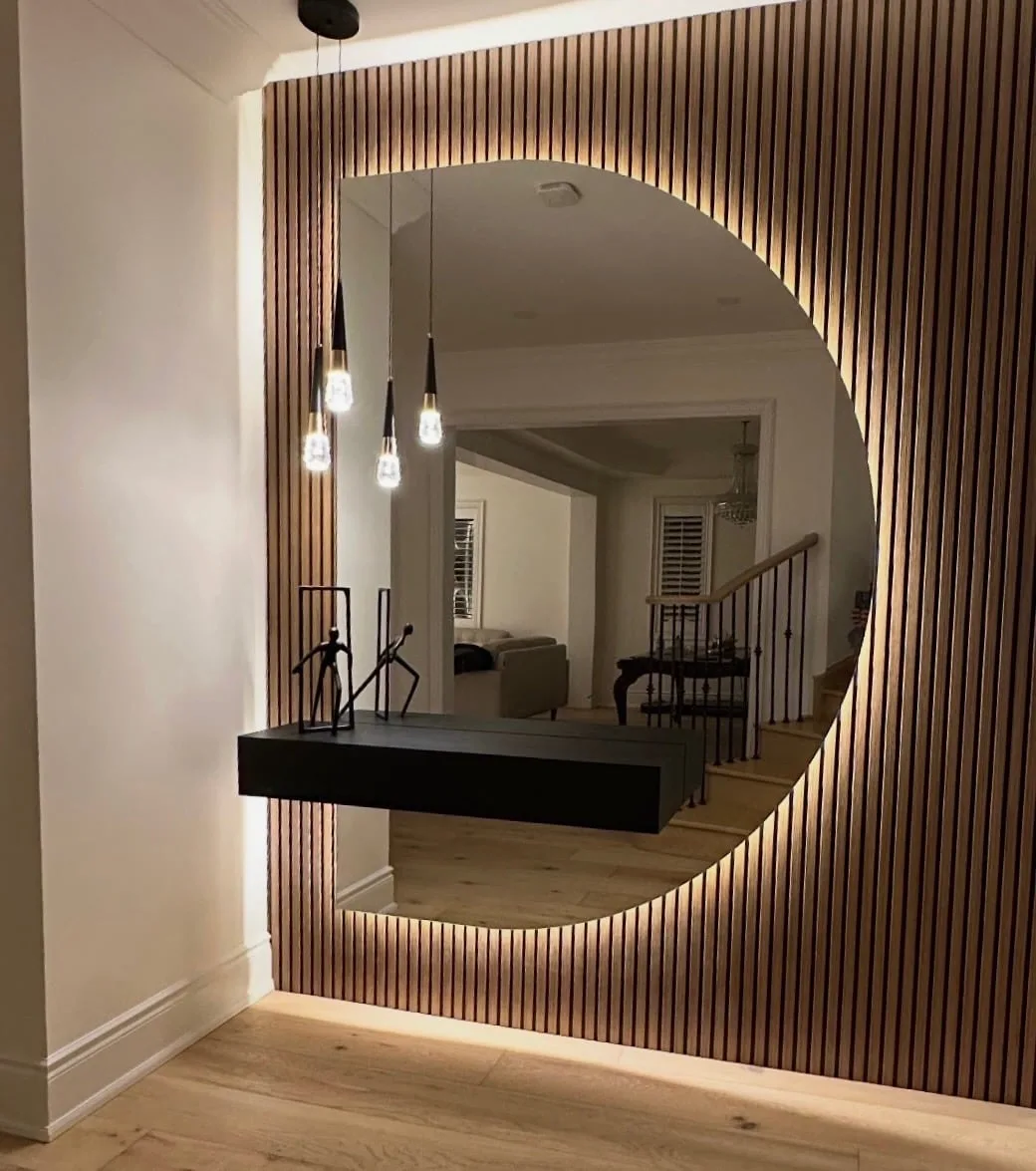 Custom round mirror with integrated backlighting above a vanity