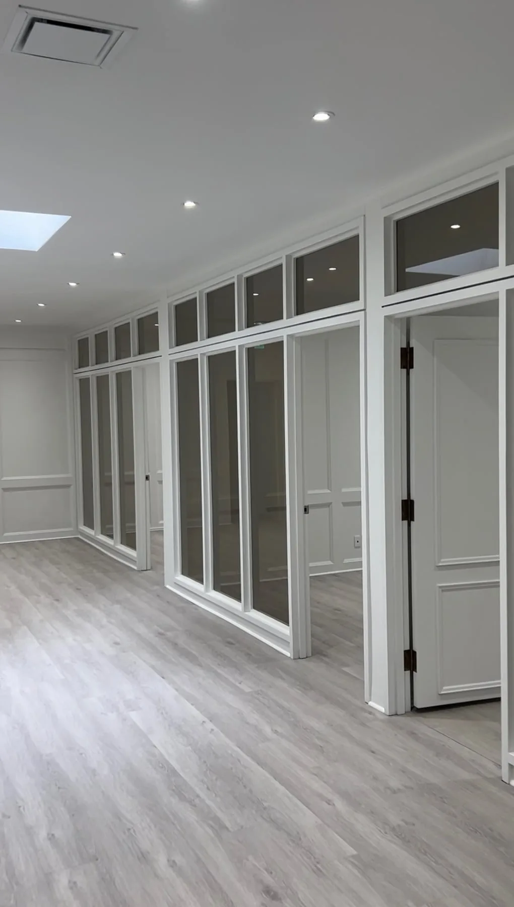 Cut-to-size glass panels installed in a millwork partition system