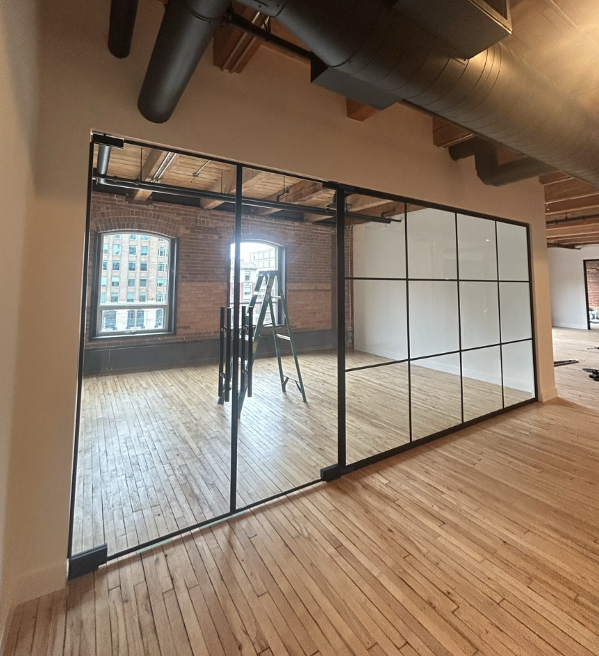 Black aluminum framed architectural glass partition system in a modern interior