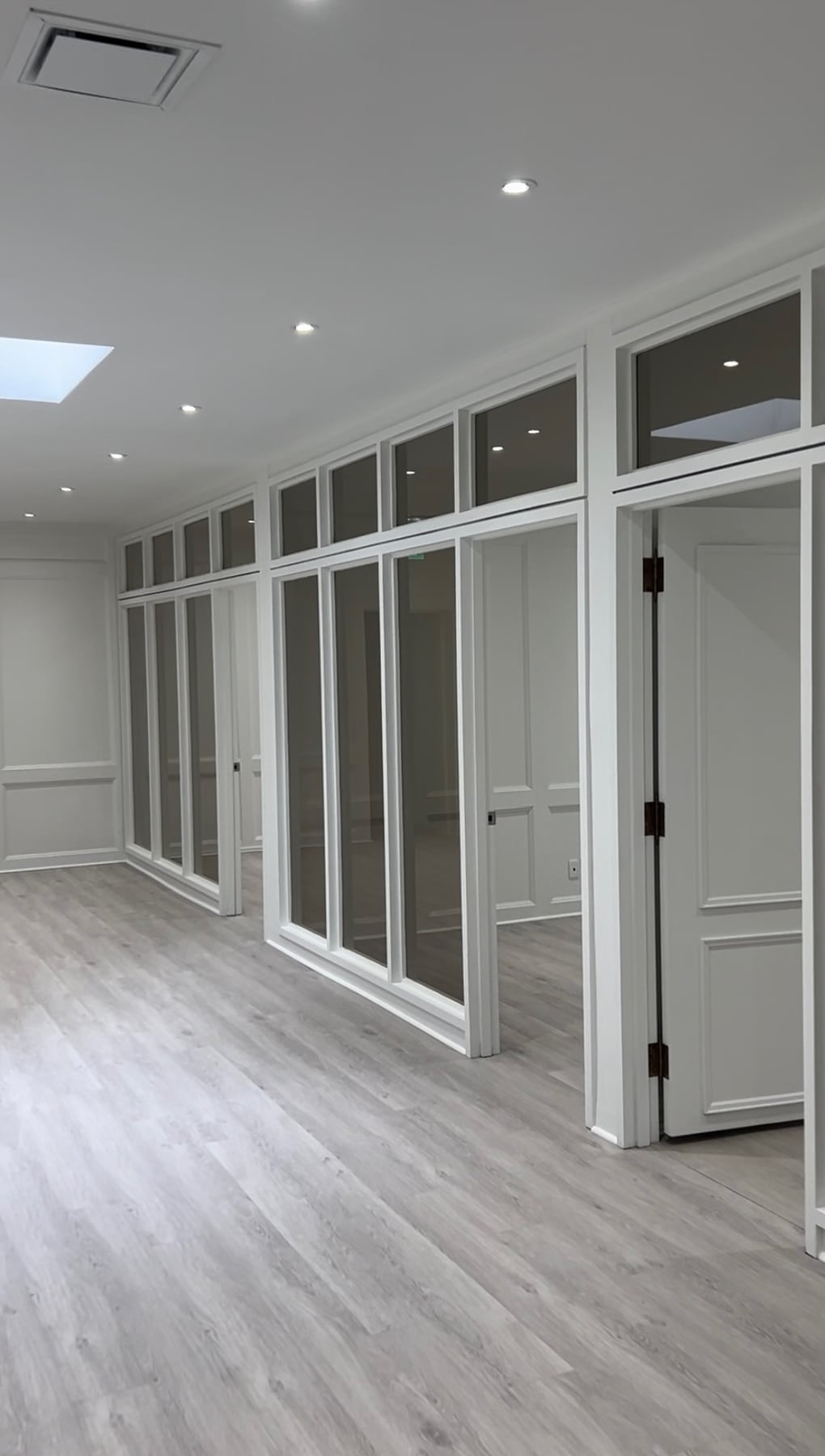 Cut-to-size glass panels installed in a millwork partition system